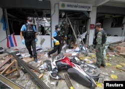 Security personnel inspect the Kok Po district office after being attacked by a group of gunmen in Pattani province, south of Bangkok, Sept. 11, 2014.