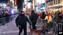 纽约一名警察牵着警犬在时报广场巡逻。（2017年12月31日）
