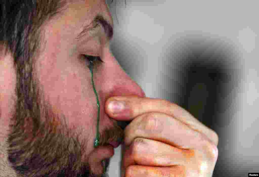 Artist Leandro Granato cries out paint onto a canvas at his studio in the Alejandro Korn town in greater Buenos Aires, Argentina, Oct. 10, 2013. Granato paints using a unique technique that consists of taking in the paint through his nose and squirting it out through his eyes onto a canvas.