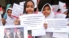 Anak-anak sekolah dasar dari Solo menunjukkan poster-poster dan foto Presiden Joko Widodo dan Wakil Presiden Ma'ruf Amin menjelang pelantikan presiden dan wapres terpilih di Solo, 19 Oktober 2019. (Foto: AFP)