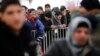Migrants queue inside a tent at the compound outside the Berlin Office of Health and Social Affairs (LAGESO) waiting to register in Berlin, Germany, Dec. 1, 2015. 