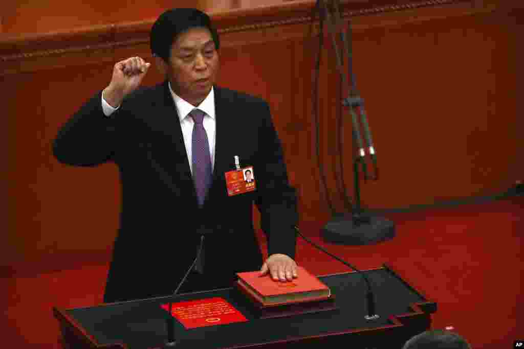 新当选的中国人大委员长栗战书2018年3月17日在全国人大全体会议上手按宪法，宣誓就职。