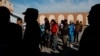 Migrants wait in line for food at a camp containing hundreds of migrants who arrived at the U.S. border from Central America in a caravan with the intention of applying for asylum in the U.S., in Tijuana, Mexico, Dec. 12, 2018. 