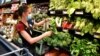 FILE - Crystal Dvorak shops at WinCo Foods, May, 7, 2021, in Billings, Mont. Dvorak was getting ingredients to make soup with potatoes and onions she got from a food bank after recently losing her job as an audiologist. 