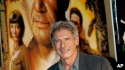 هریسون فورد در کنار یک پوستر فیلم ایندیانا جونز - آرشیو