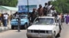 FILE - Vigilantes and local hunters armed with machetes and guns shout slogans as they gather outside the Emir's palace for a royal blessing to fight Islamist Militants in Maiduguri, Nigeria, Sept. 4, 2014. 