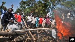 Demonstrators burn tires to protest the results of the Orange Democratic Movement (ODM) primary elections, in Aherou, Kenya on Sunday, Jan. 20, 2013. This week, political parties held internal elections to decide candidates who will vie for gubernatorial, senate, county and women representatives seats in the upcoming March 4 elections.