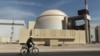FILE - A worker rides a bicycle in front of the reactor building of the Bushehr nuclear power plant, just outside the southern city of Bushehr, Iran. The most successful publicly known cyberattack on a nuclear facility was caused by a virus called Stuxnet, which apparently prompted the Iranian facility's centrifuges to spin out of control and break down. 