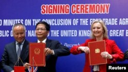 Britain's International Trade Secretary Liz Truss and Vietnam's Minister of Industry and Trade Tran Tuan Anh at a Hanoi signing ceremony of a free trade deal, Dec11, 2020. 