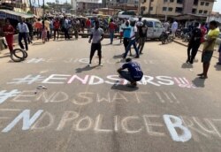 FILE - A demonstrator paints 'End Sars', referring to the Special Anti-Robbery Squad police unit, on a street during a protest demanding police reform in Lagos, Nigeria, Oct, 20, 2020.