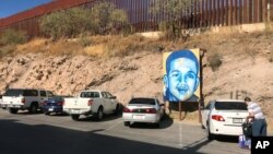 A portrait of Jose Antonio Elena Rodriguez, 16, a Mexican who was shot and killed in Nogales, Sonora, Mexico, is displayed on the street where he was killed that runs parallel with the U.S. border, Dec. 14, 2017. The U.S. Border Patrol agent who was charged in the teen's death will be retried, prosecutors announced May 11, 2018.
