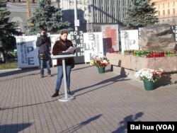 宣读政治迫害遇难者的姓名，每份名单有5名遇难者 (美国之音白桦拍摄)