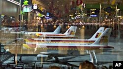 Iberia planes are seen parked up as passengers wait at Barajas Airport in Madrid, 04 Dec. 2010
