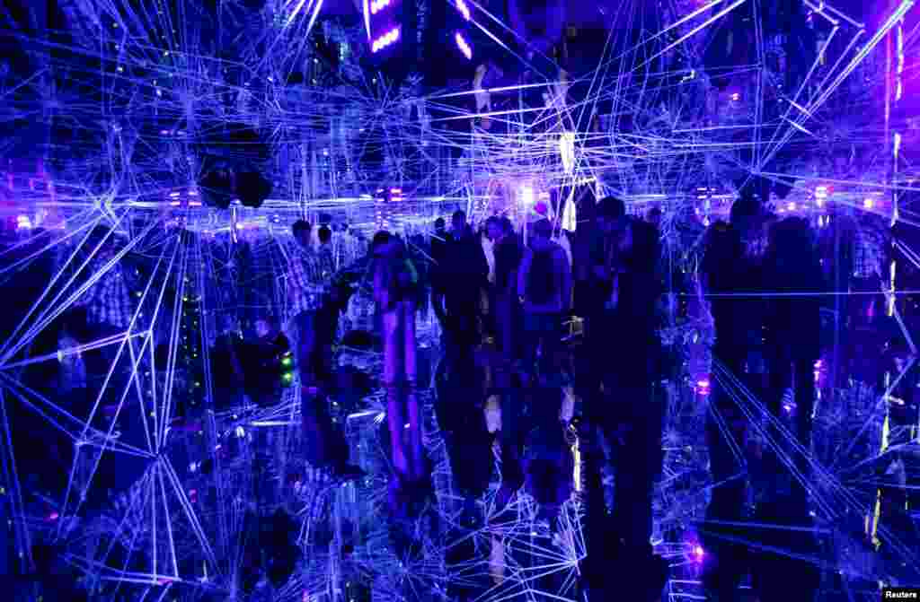 Visitors are reflected in mirrors inside an installation at the contemporary design festival Designblok 2013 in Prague, Czech Republic.