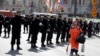 FILE - A sweeper walks past police officers as they stand guard during a rally of Russian opposition supporters in Moscow, May 6, 2017.