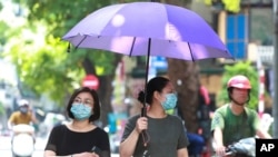 Women wearing face masks walk on the street in Hanoi, Vietnam, Thursday, July 30, 2020. Vietnam on Thursday reported several more cases of COVID-19, as the first outbreak in over three months spread to cities while authorities say they cannot trace…
