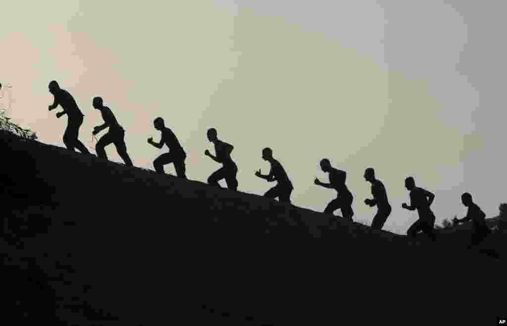 Para mahasiswa akademi kepolisian Al-Rebat, Palestina, melakukan latihan militer setelah matahari terbenam di Khan Younis, Jalur Gaza.