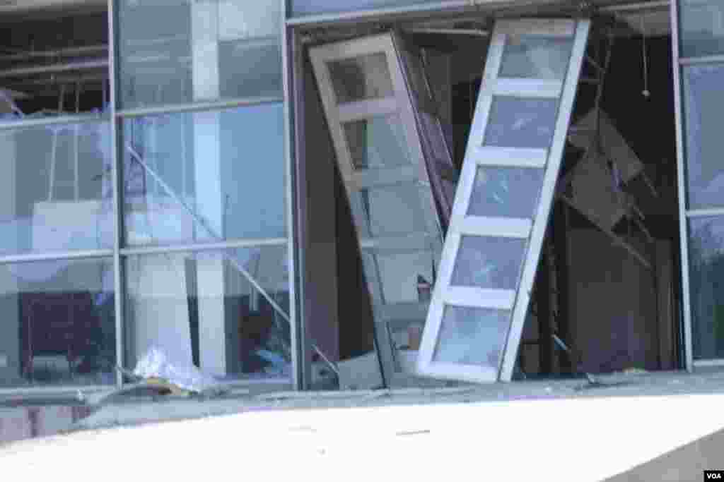 天津爆炸事故现场，核心爆炸区周围多座居民楼窗户被震碎，高速公路桥梁受损，多辆大货车被炸翻，小汽车起火或被砸，多名当地居民仍逗留在事故现场。（美国之音记者东方拍摄）