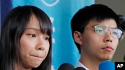 前“香港众志”的秘书长黄之锋及成员周庭（左）在一家地区法院前对媒体讲话。（2019年8月30日）