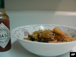 Ah, a bowl of classic Louisiana jambalaya and the sauce that gives it a spicy jolt. Jambalaya usually includes rice, shrimp, sausage, and peppers - not counting the mashed peppers in the Tabasco sauce.