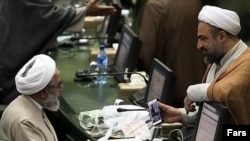 حمید رسایی نماینده مجلس ایران تصویری از حجاب عضو هیات اروپایی را به روح الله حسینیان نشان میدهد