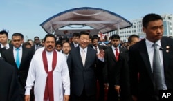 2014年9月17日，习近平主席和斯里兰卡总统拉贾帕克萨（身穿白衣者）在启动科伦坡的港口城项目后一起行走