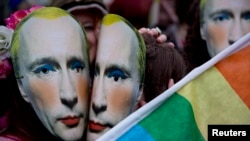 U.K. -- Protesters wearing masks of Russia's President Vladimir Putin pretend to kiss as they take part in a demonstration against the country's 'anti-gay' laws outside the Embassy of the Russian Federation in London, February 14, 2014.