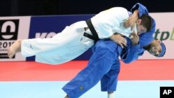FILE - Luka Maisuradze of Georgia, top, competes against Saeid Mollaei of Iran during a men's -81 kilogram bronze medal match of the World Judo Championships in Tokyo, Aug. 28, 2019. 