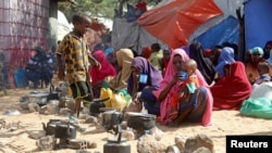 FILE - Somali families, displaced after fleeing the Lower Shabelle region amid an uptick in U.S. airstrikes, wait at an IDP (internally displaced person) camp near Mogadishu, Somalia, March 12, 2020.