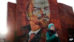 FILE - A boy pauses for photos in front of a mosaic portrait of Vladimir Lenin on Feb. 20, 2014, in Sochi, Russia. (AP Photo/Jae C. Hong)