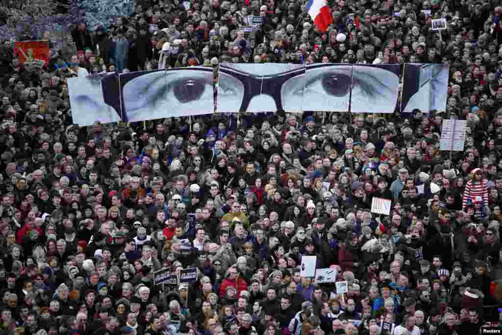 People hold panels to create the eyes of late Charlie Hebdo editor Stephane Charbonnier, known as &quot;Charb&quot;, as hundreds of thousands of French citizens take part in a solidarity march (Marche Republicaine) in the streets of Paris, Jan. 11, 2015. French citizens were joined by dozens of foreign leaders in a march in an unprecedented tribute to this week&#39;s victims following the shootings by gunmen at the offices of the satirical weekly newspaper Charlie Hebdo, the killing of a police woman in Montrouge, and the hostage taking at a kosher supermarket at the Porte de Vincennes.