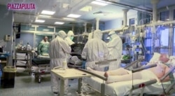FILE - Medical staff in protective suits treat coronavirus patients in an intensive care unit at the Cremona hospital in northern Italy, in this still image taken from a video, March 5, 2020.