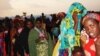 FILE - Women and children holding their pink tickets queue for the evening meal at the Dollo Ado transit center in Ethiopia, October 26, 2011. (VOA P. Heinlein)