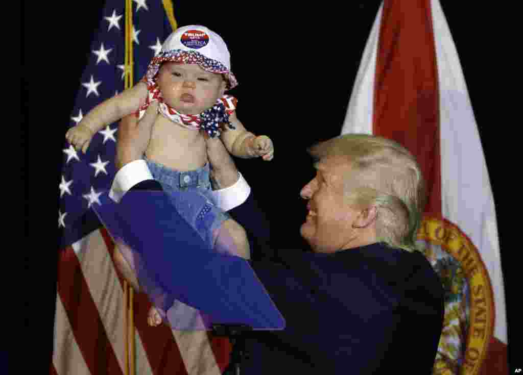 川普在竞选活动中抱着一个婴儿