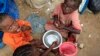 Internally displaced Somali children eat breakfast at Sayyidka camp in the Howlwadag district, south of Somalia's capital Mogadishu, May 3, 2013. 