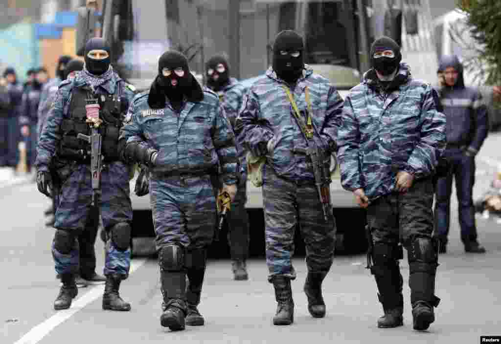 Para anggota unit anti-huru-hara Berkut bersiap meninggalkan barak-barak mereka di Kyiv (22/2). Kepala-kepala empat badan keamanan Ukraina, termasuk unit anti Berkut dari kepolisian, muncul di parlemen dan menyatakan tidak akan ambil bagian dalam konflik apa pun dengan warga.