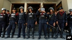 12일 태국 방콕 정부 청사 주변에서 반정부 시위가 계속된 가운데, 경찰들이 산림부 청사 입구를 지키고 있다.