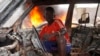 A Christian youth squats inside a burnt out car in Bangui December 10, 2013. 