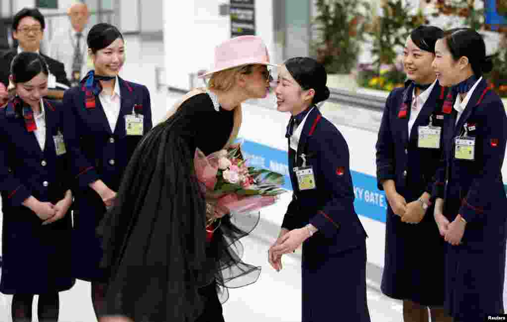 Singer Lady Gaga kisses a Japan Airlines staff member upon her arrival at Narita International Airport in Narita.