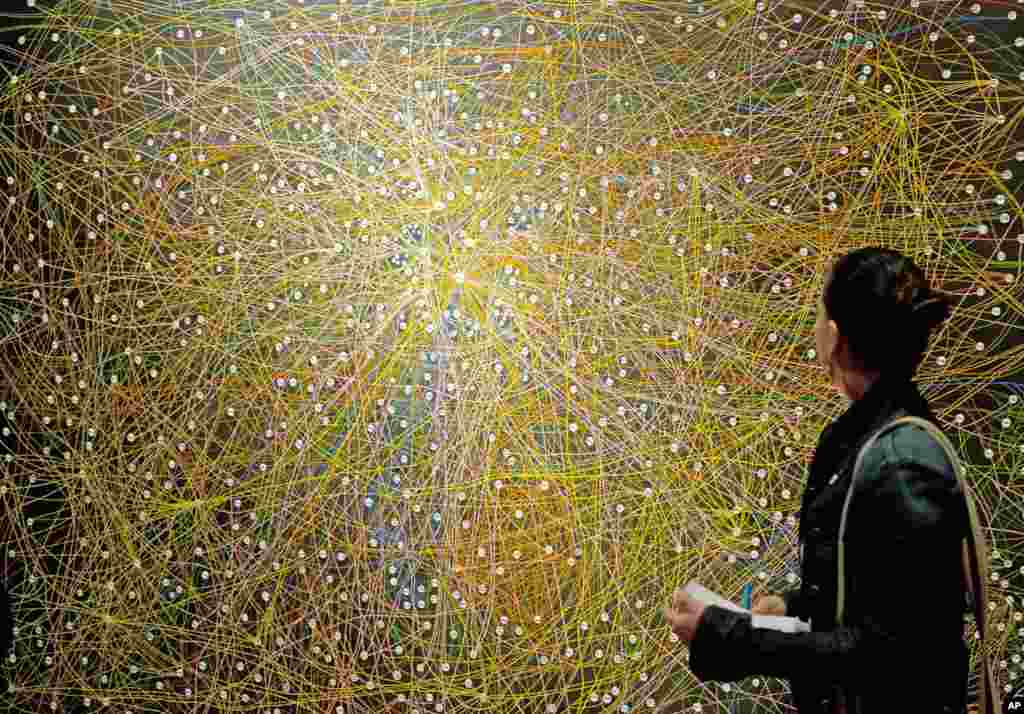 Seorang wanita berdiri di depan lukisan &quot;Koneksi-koneksi Lukisan (2007)&quot; dalam pameran &quot;Majalah dan ensiklopedia&quot; oleh artis dari Sekolah New Leipzig, Paule Hammer di Museum Kota Jena, Jerman. 