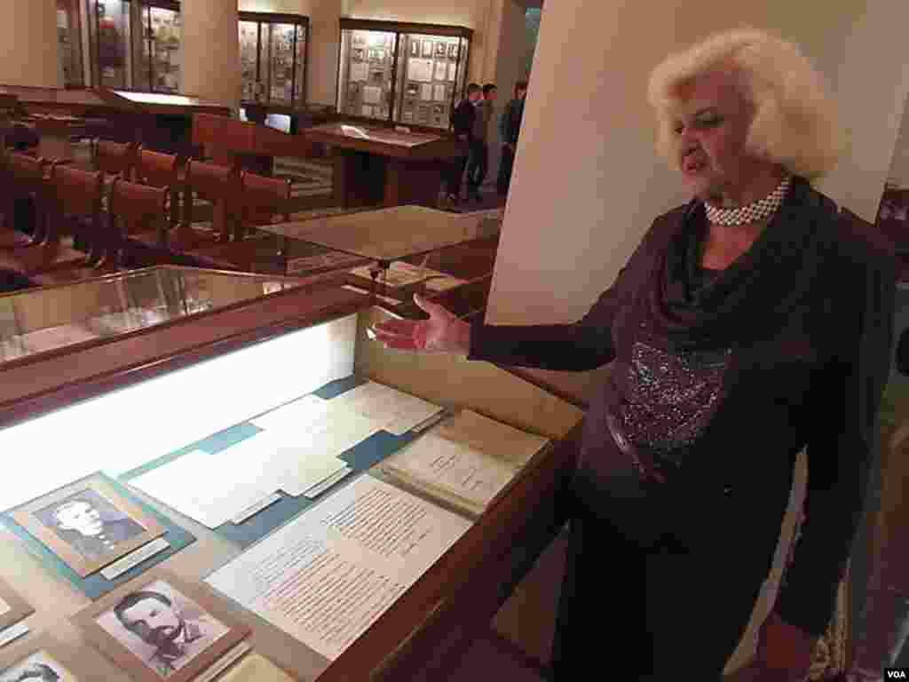 校史博物馆馆长皮萨列娃介绍列宁。左上是列宁入校时的照片，旁边是列宁的保证书。(美国之音白桦）