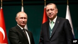 블라디미르 푸틴 러시아 대통령과 레제프 타이이프 에르도안 터키 대통령이 11일 터키 앙카라에서 정상회담 후 공동기자회견에서 악수하고 있다. 