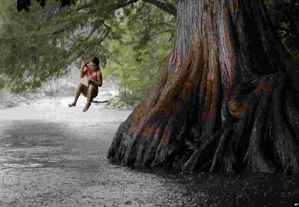 Anna Endsley bergantung di pohon di sungai Guadalupe, di kota Gruene, Texas, AS.