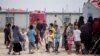 Women and children gather in front their tents at al-Hol camp that houses some 60,000 refugees, including families and supporters of the Islamic State group, many of them foreign nationals, in Hasakeh province, Syria on May 1, 2021.