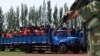 FILE - Criminals and suspects are transported to a stadium for a mass sentencing rally in Yili, Xinjiang Uighur Autonomous Region, May 27, 2014. 