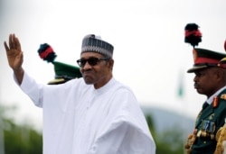 FILE - Nigerian President Muhammadu Buhari waves to the crowd while he drives around the venue during his inauguration for a second term in Abuja, Nigeria, May 29, 2019.