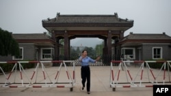 2013年9月12日，北京郊区秦城监狱入口处,一名女警员试图阻止记者拍照。