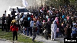 지난 10일, 시리아 반군거점 지역 홈스에서 UN 차량 주변에 주민들이 모여있다.