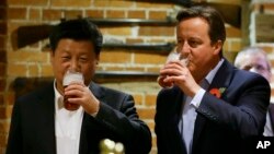 영국을 방문 중인 시진핑 중국 국가주석(왼쪽)이 22일 캐머런 영국 총리와 체커스 인근 술집에서 맥주를 함께 마시고 있다.