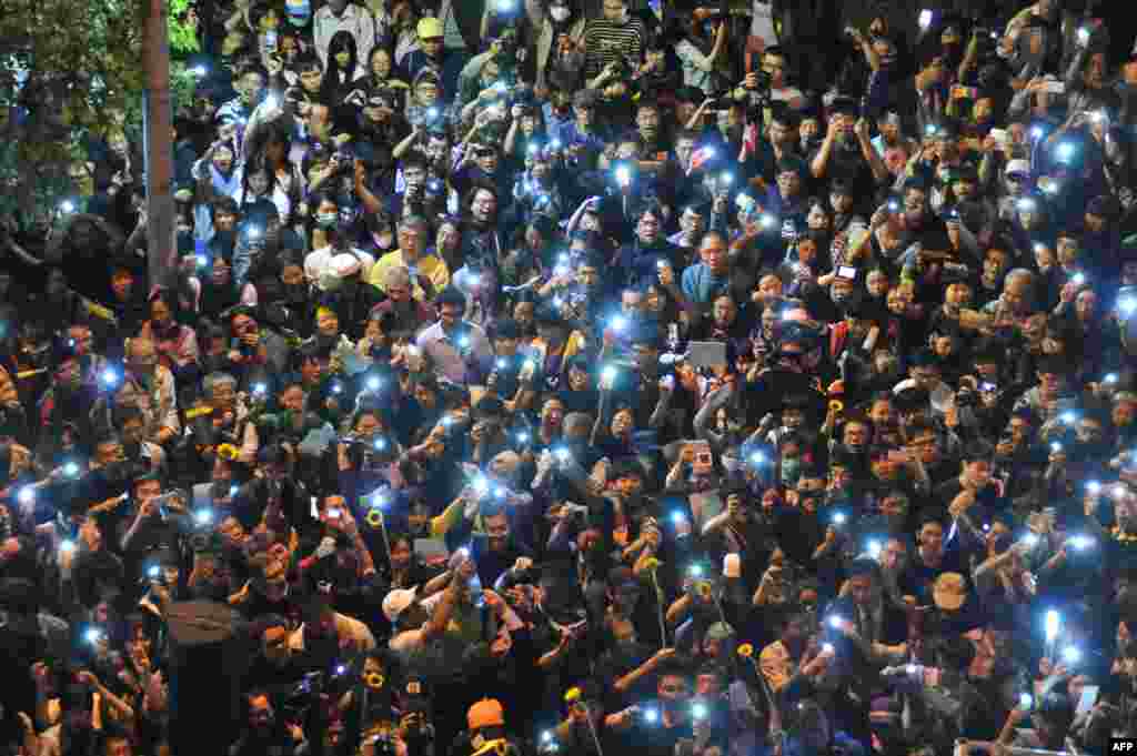 Protesters use their phones to show lights outside the parliament building in Taipei, Taiwan, after an occupy protest ended over a contentious trade pact with China.